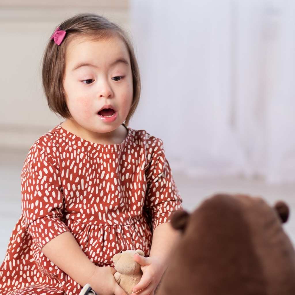 A child engaged in play, appearing to vocalize as they look to a toy. This image aligns with the question 'Why Isn’t My Toddler Talking Yet' and highlights common worries around speech delay