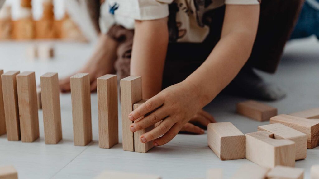 A toddler lines up toys in a neat row, a behavior some children use for comfort or focus, which can also appear in children with autism.
