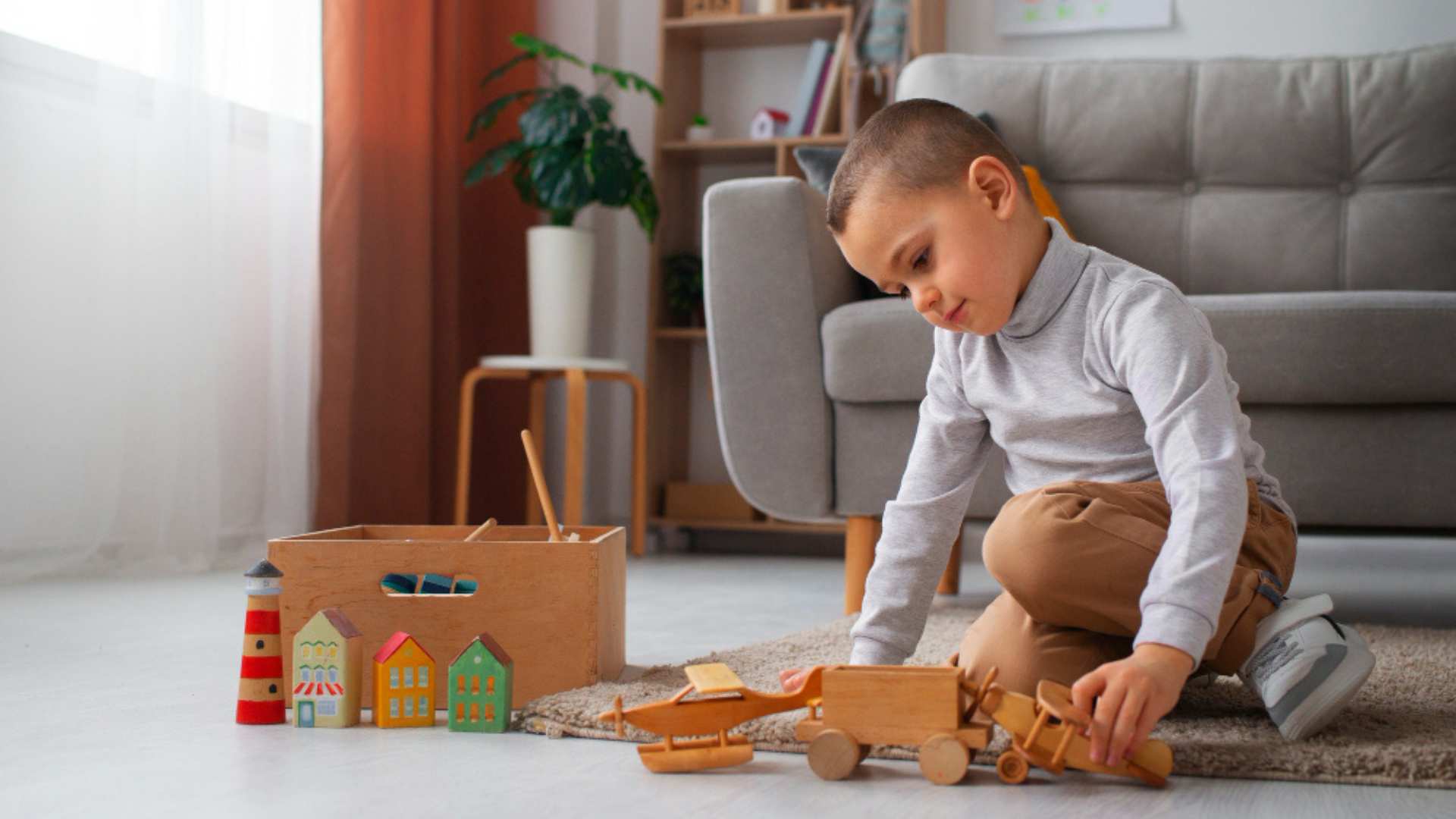 A toddler lines up toys while playing, a behavior where they place objects in order to explore patterns