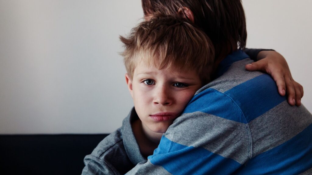 Parents comforts child after they've received an autism diagnosis