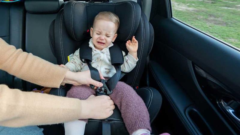 Car Seat Sensory Issues in Autism: A Supportive Guide for Parents and Caregivers 1 Crying toddler resisting car seat buckle, illustrating autism-related car seat refusal and sensory discomfort.