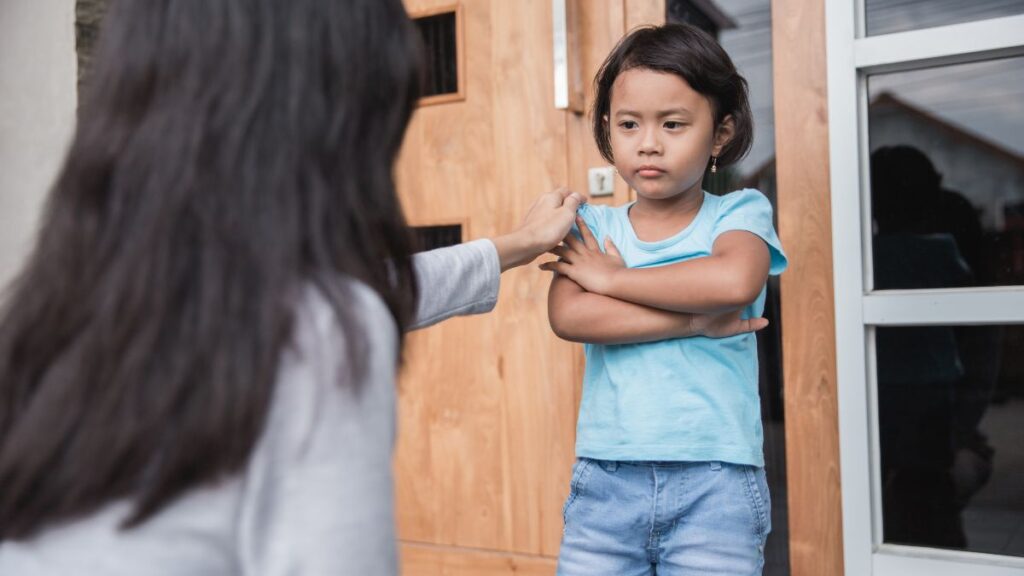 Mother tries to coax her daughter who demonstrates the challenging behavior of refusing to leave