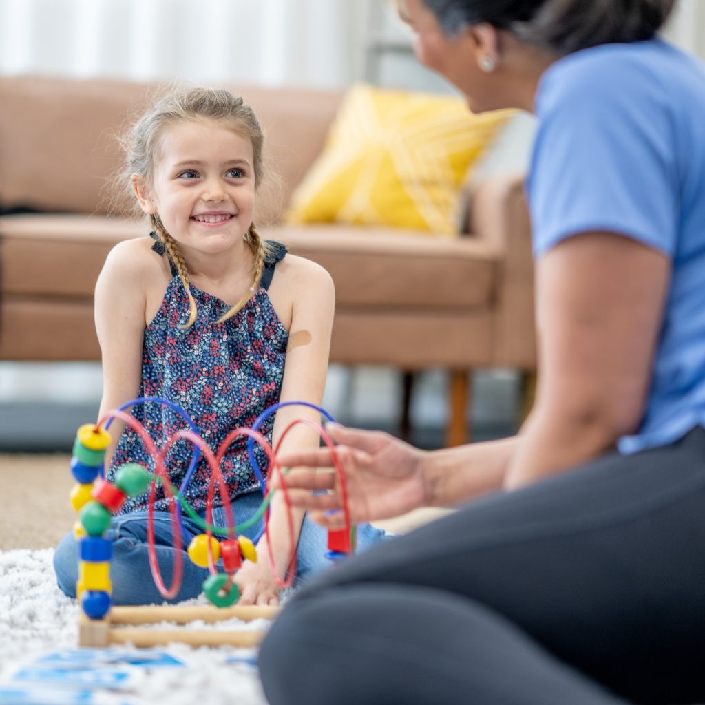 Child engaging with a colorful toy during a play-based ABA session