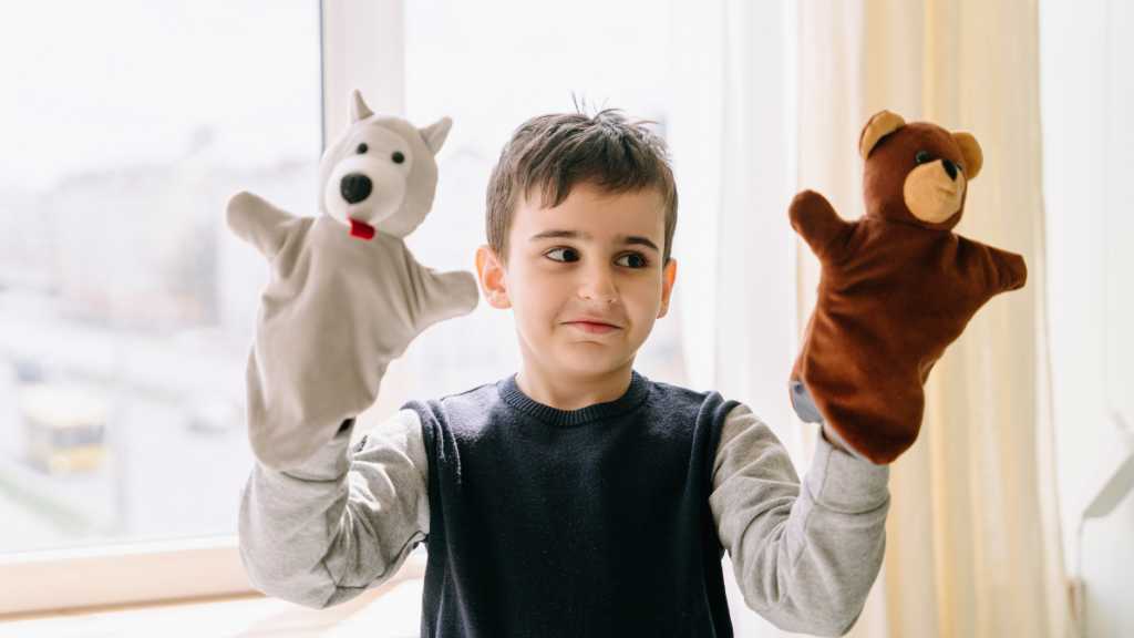 Understanding Level 1 autism and daily social communication differences. .Child playing with hand puppets
