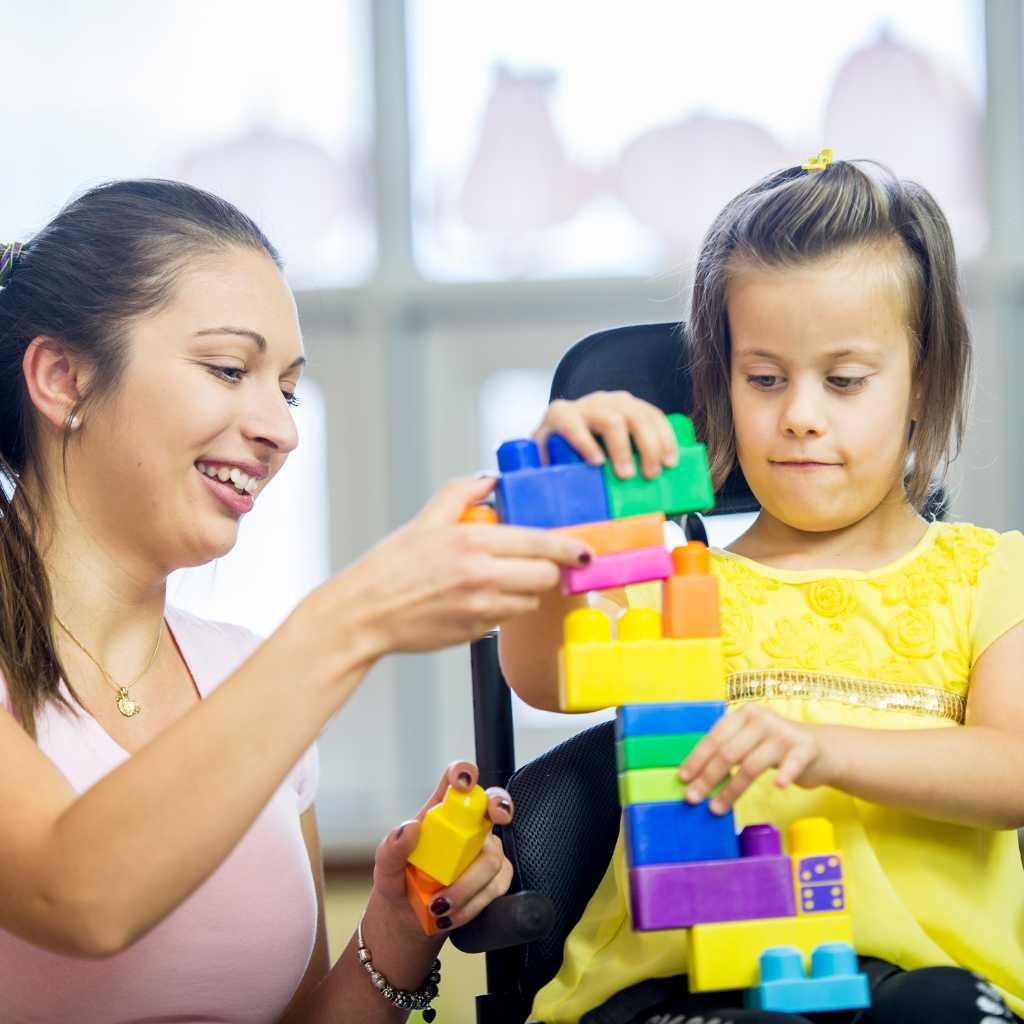 Teacher interacting with young children during playtime, representing early intervention and support that go beyond autism level classifications.