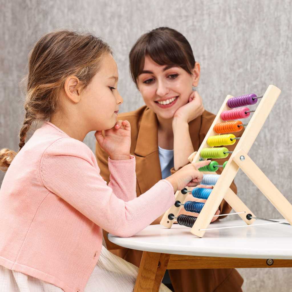 Child learning with colorful abacus during therapy session — illustrating traits of Level 1 autism.