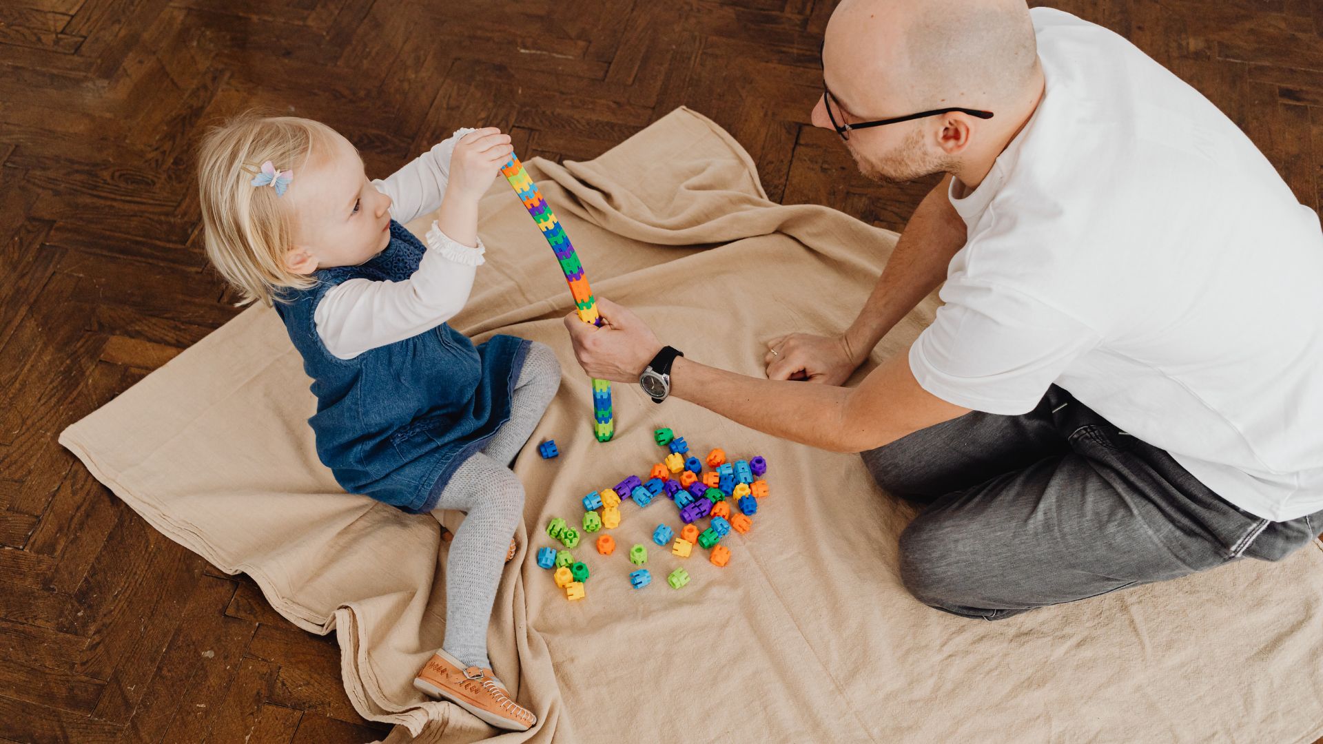 Parent and young child building with colorful blocks during playtime