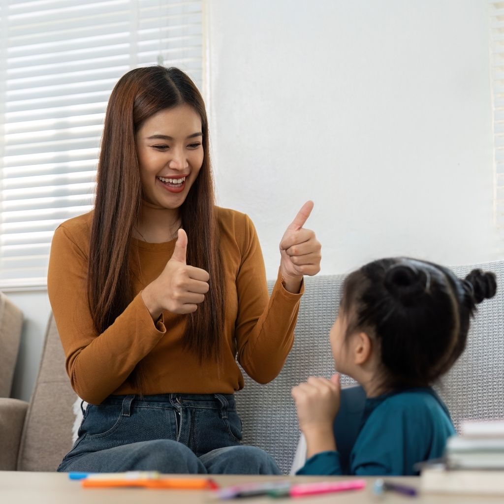 Adult giving positive feedback to a young child during a learning activity