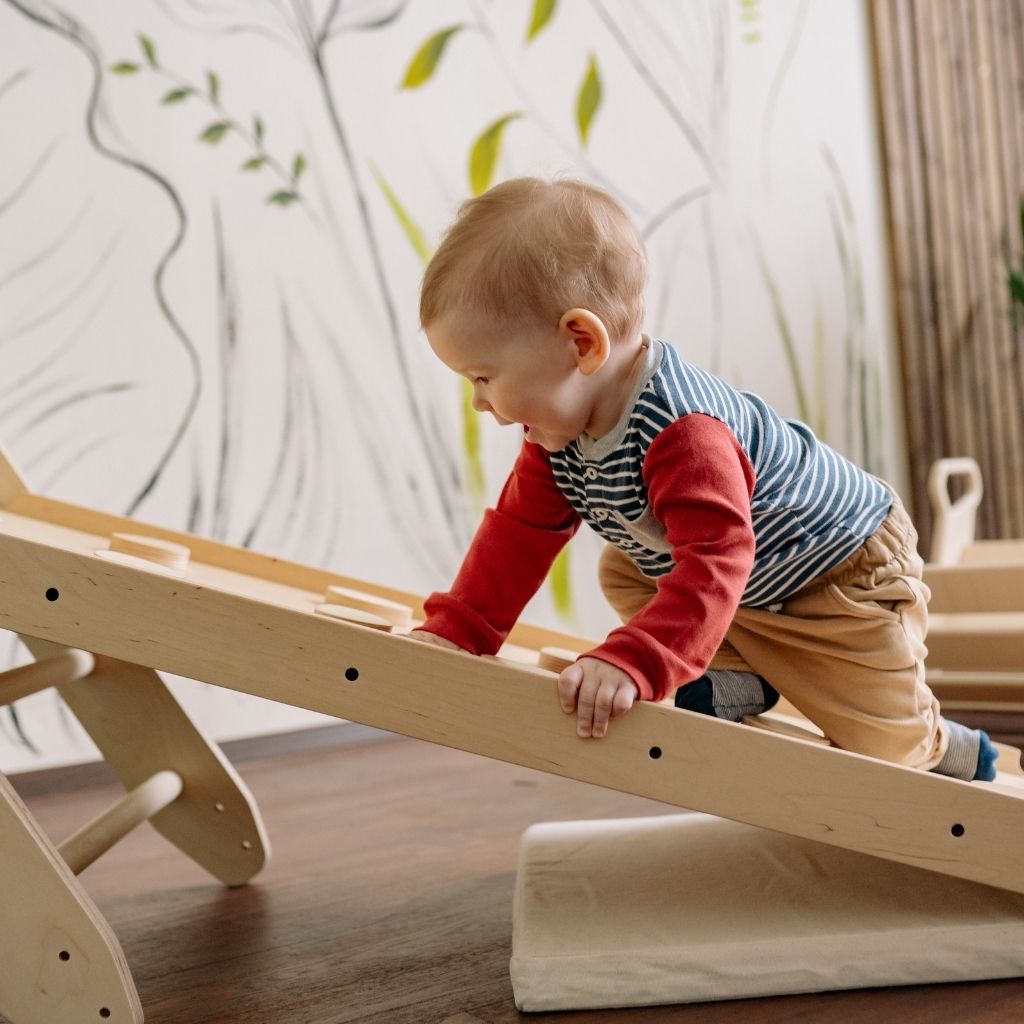Toddler practicing movement and motor skills through a play-based activity
