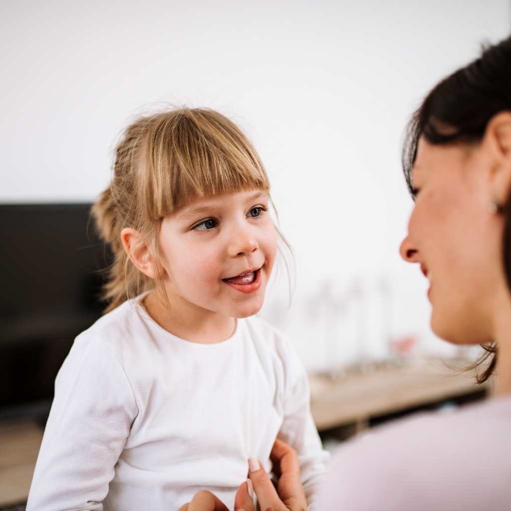 A young child talking with an adult during a calm moment, showing early communication behaviors