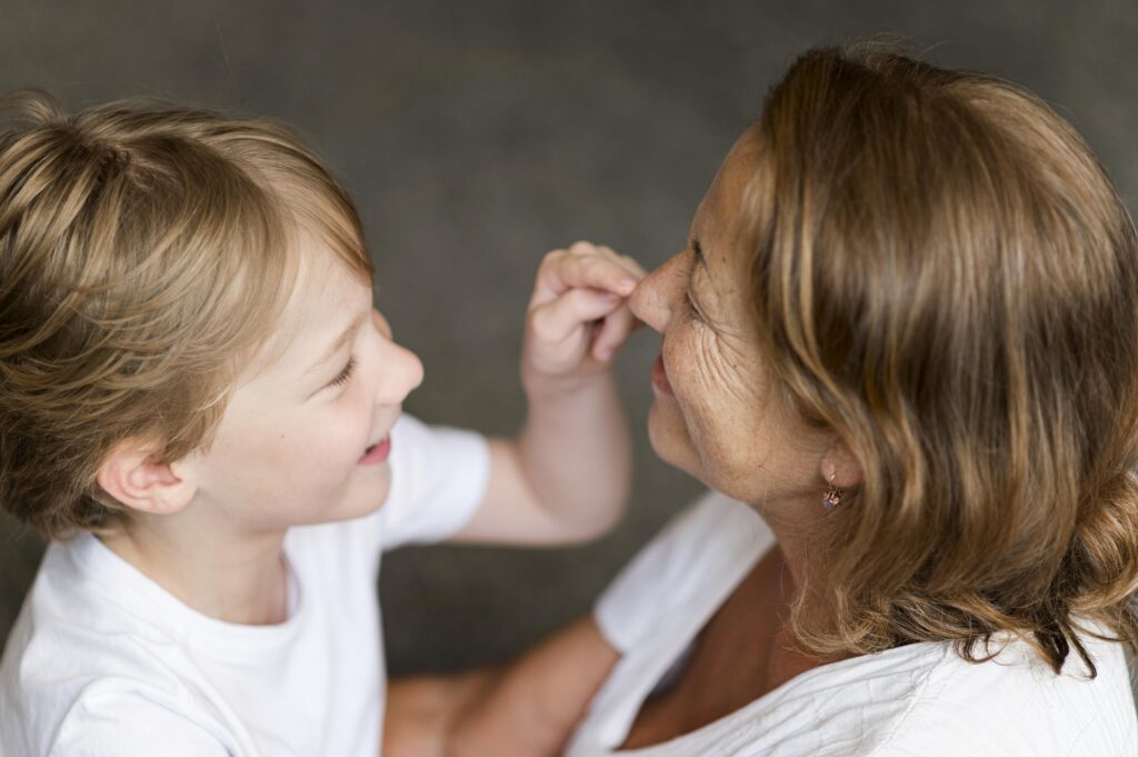 A child interacting closely with an adult, highlighting a playful connection often discussed in conversations about eye contact in autism.