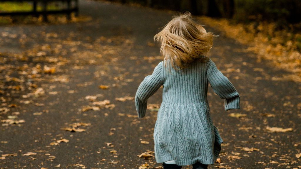 Child running along an outdoor path away from view