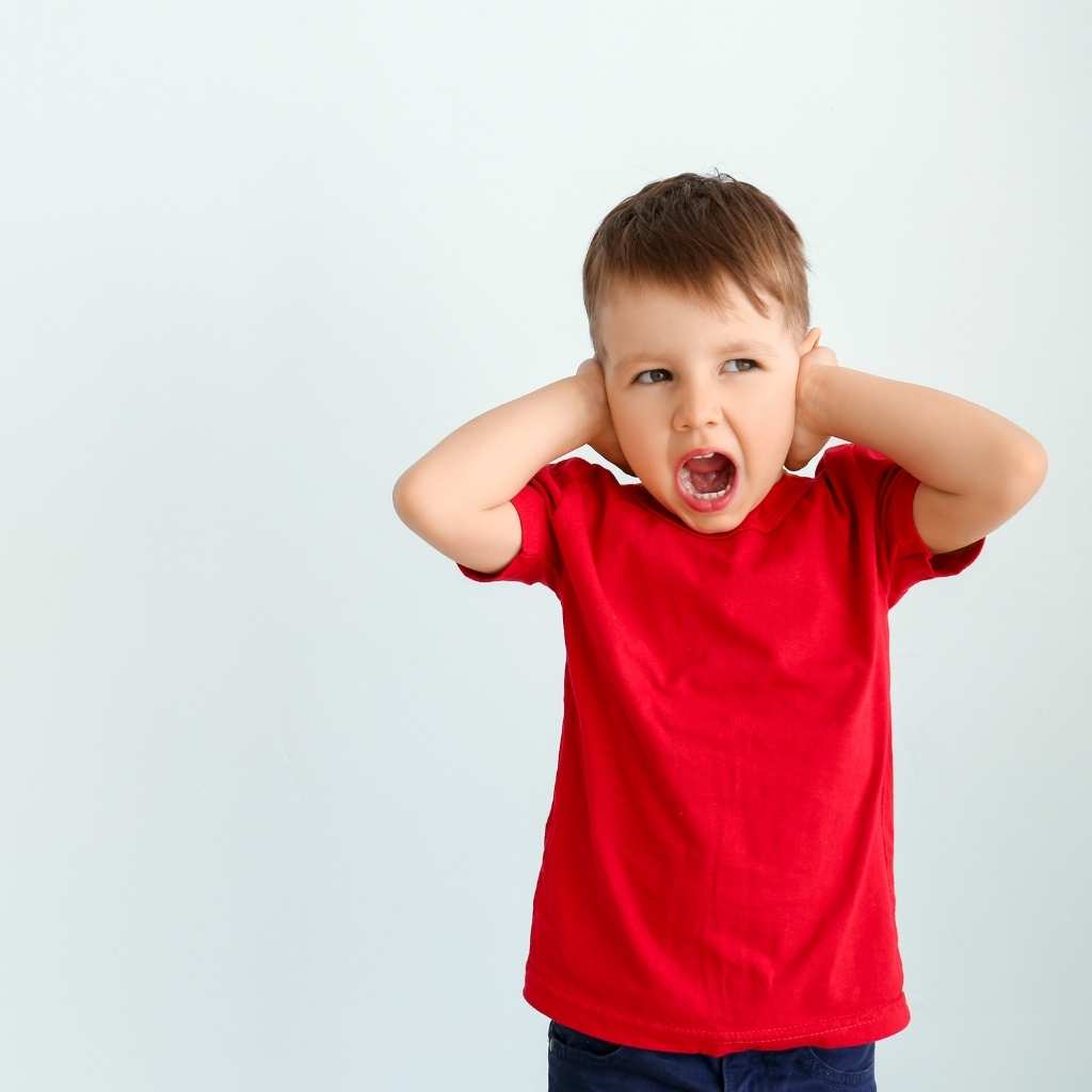 Child in a red shirt overwhelmed and crying, illustrating a meltdown
