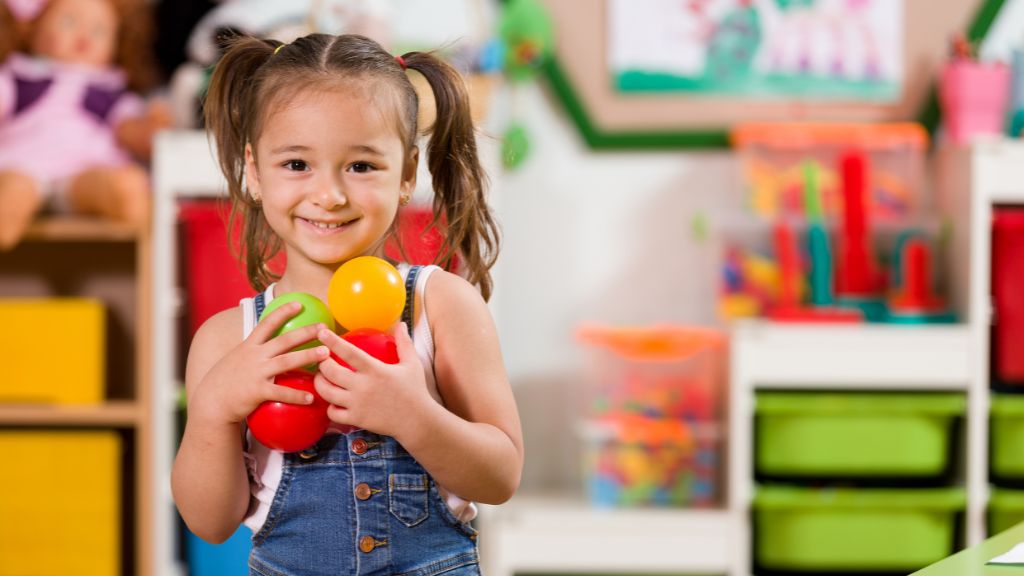 School transition for children with autism Smiling preschool child holding colorful sensory toys in a classroom